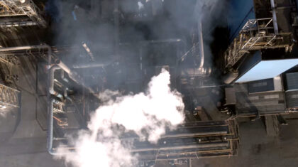 Aerial view of industrial installation with smoke emissions from pipelines