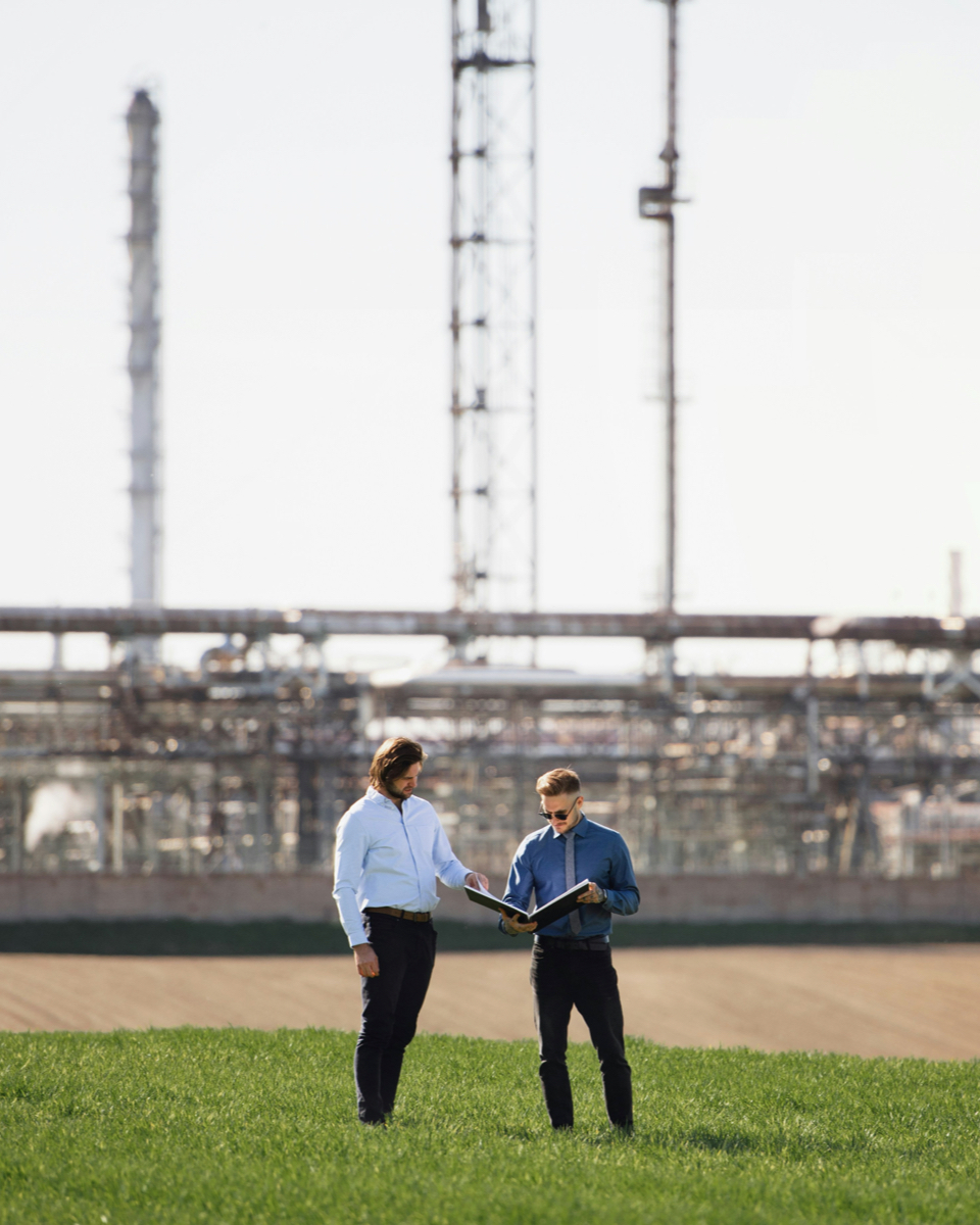 Two consultants analyzing EED audit results on-site at an industrial facility.