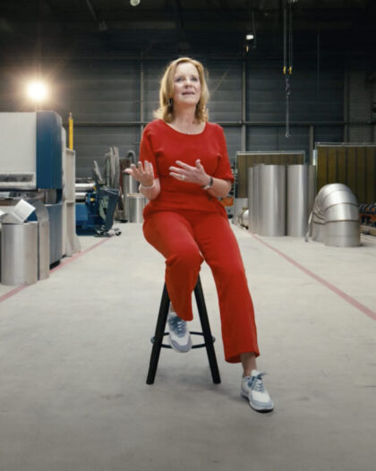 Martine Goedegebuure sitting on a stool in the Heat Matrix assembly hall during the Day of the Entrepreneur.