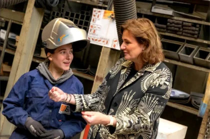 Minister Karien van Gennip in conversation with a young technician from Bos Nieuwerkerk during a working visit to the workshop.